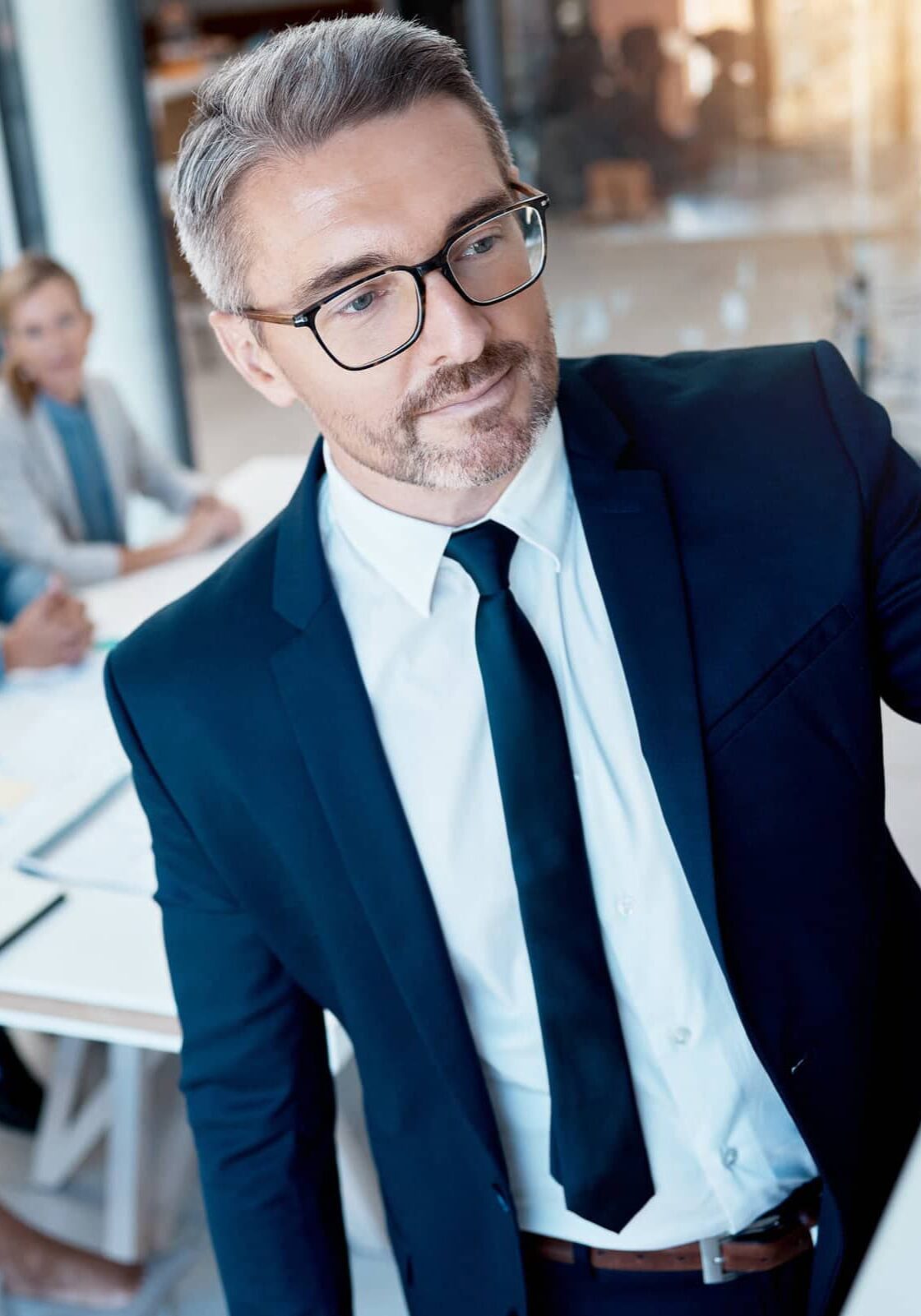 mid-age professional writing on board during meeting