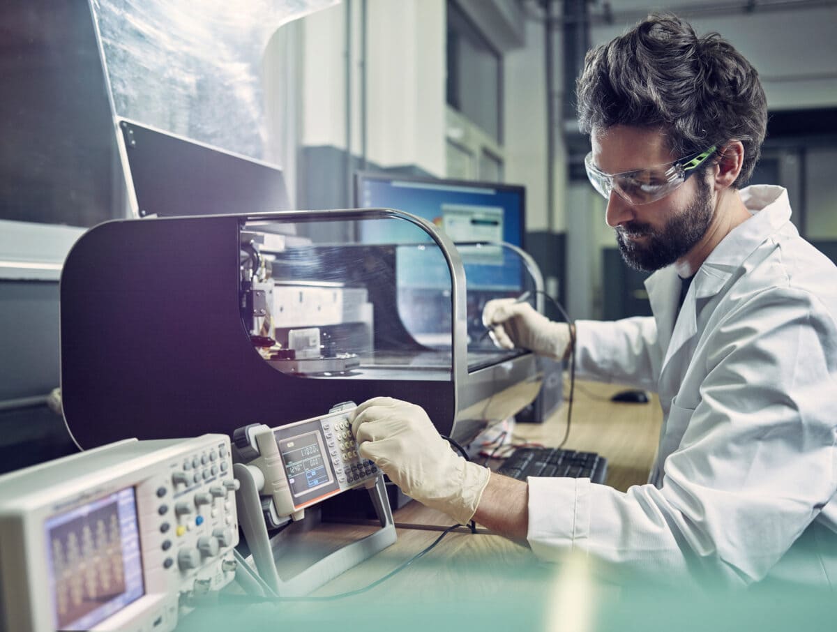 Technician operating 3d printing machine in laboratory