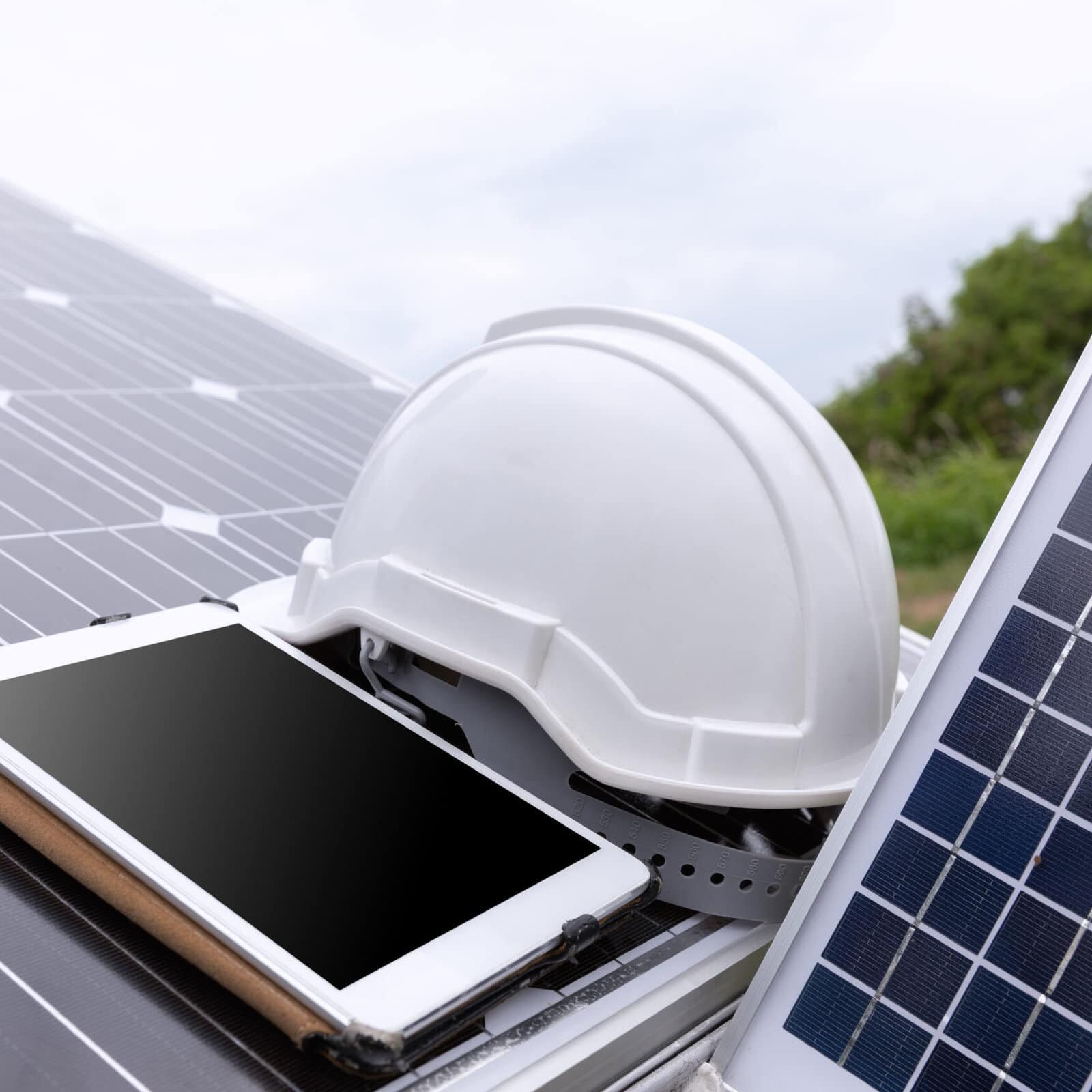 Engineer solar photovoltaic panels station checks with tablet computer.